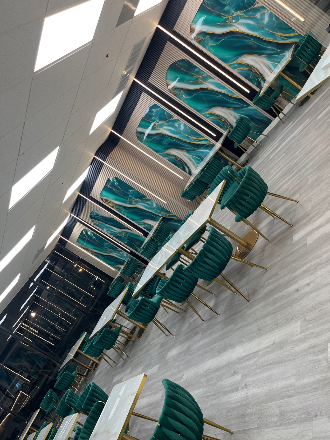 Emerald velvet booths and gold-trim chairs against teal marble panels at Sweet & Such Dessert Café